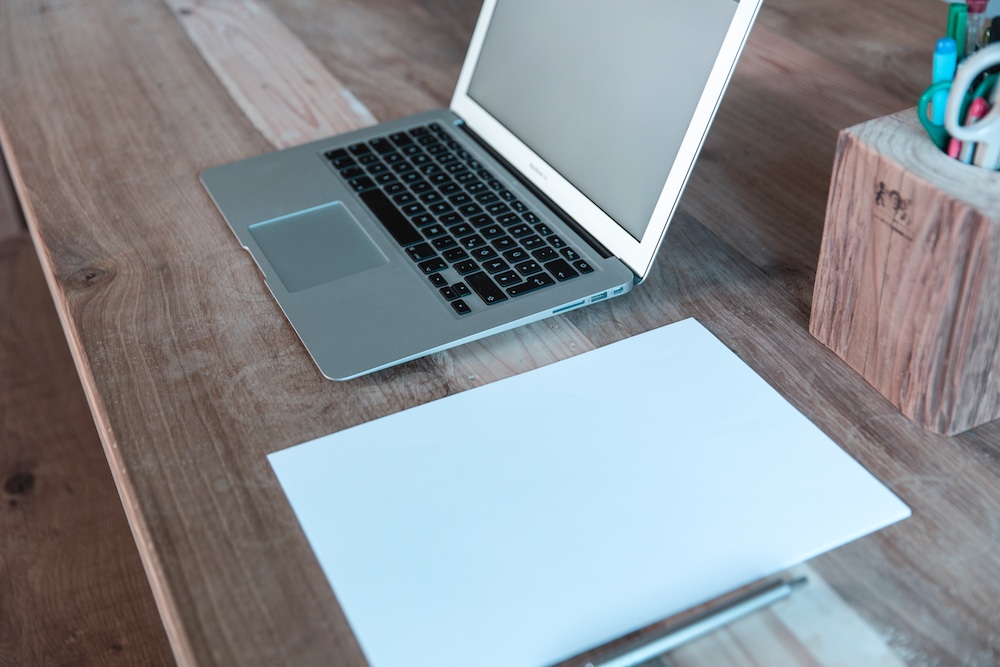 An Apple Macbook Air and paper.